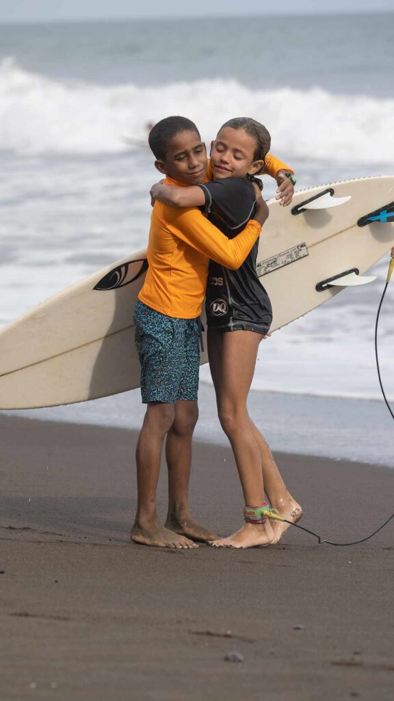 two kids hugging after a surf