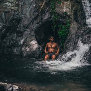 A man sitting under a waterfall in panama