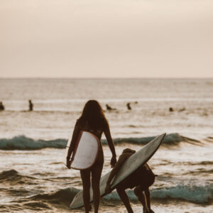 Girls getting in the water to go surf