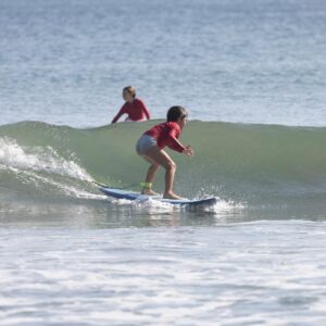Little girl surfing a small wave